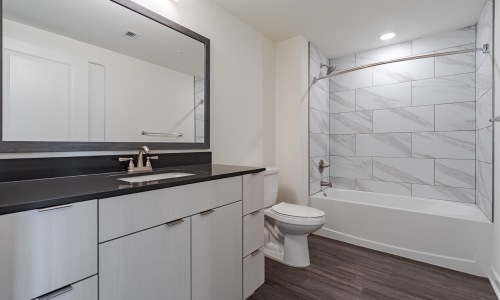 bathroom with a sink, large vanity and mirror and ample lighting - Rivermark Northern Liberties townhomes for rent in Philadelphia 