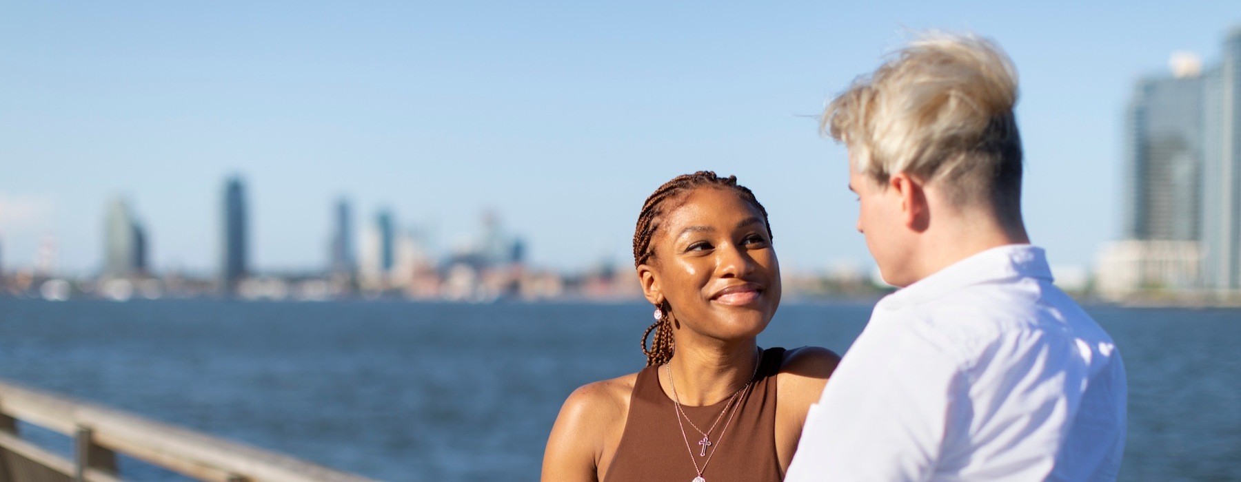 a couple standing on a bridge over water
